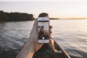 En 2011, l'engouement pour les petits écrans explose. L'image montre une smartphone tenue par un canotier au milieu d'un lac.